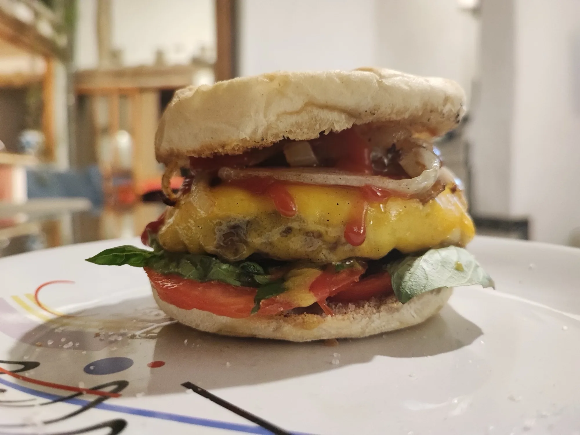 Hamburguesa con queso fundido en pan redondo sobre un plato blanco