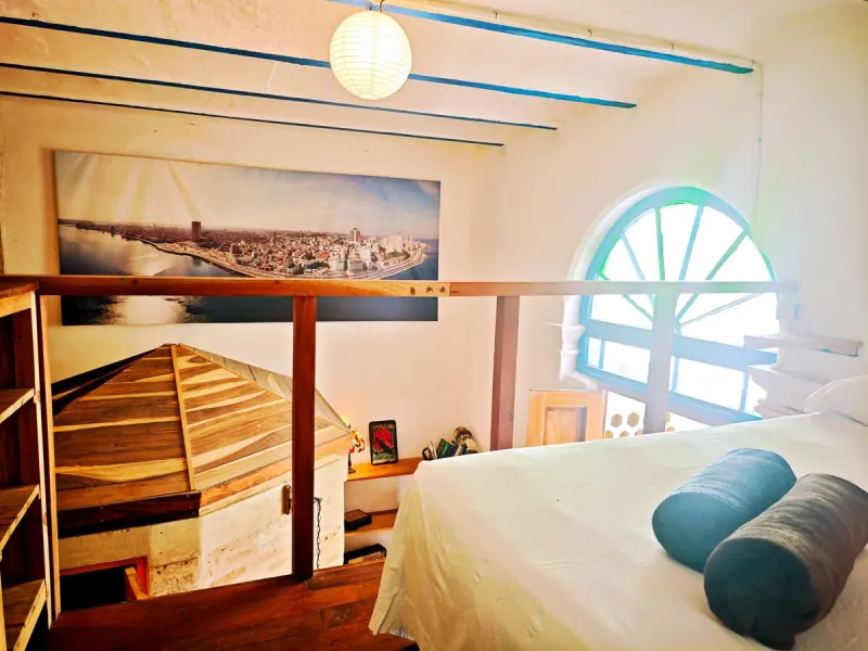 Chambre avec une fenêtre en arc et un lit double